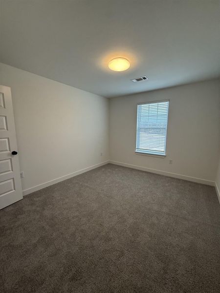 Spare room featuring carpet and baseboards
