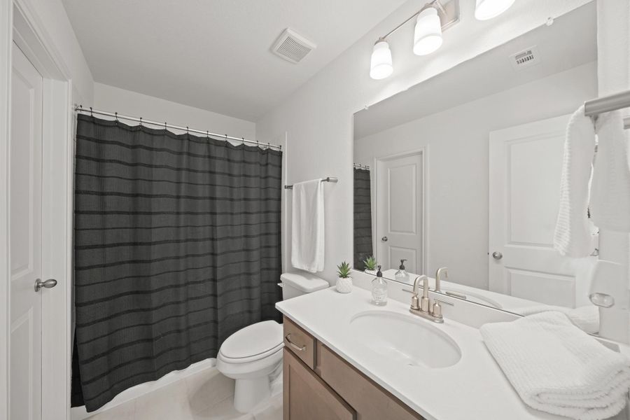 Private bathroom adjoining a secondary, upstairs bedroom.