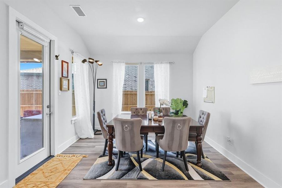 Dining area with plenty of natural light, vaulted ceiling, wood-style finished floors, and recessed lighting Dining area with plenty of natural light, vaulted ceiling, wood-style finished floors, and recessed lighting
