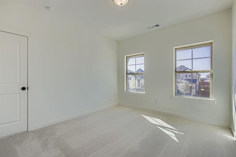 Spare room with light carpet and baseboards Spare room with light carpet and baseboards