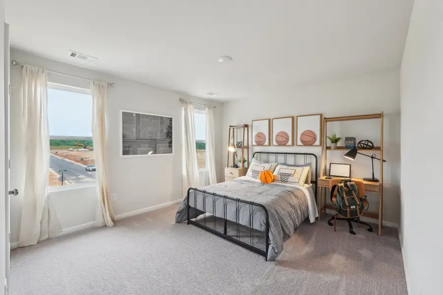 A bedroom with a bed and a chair.