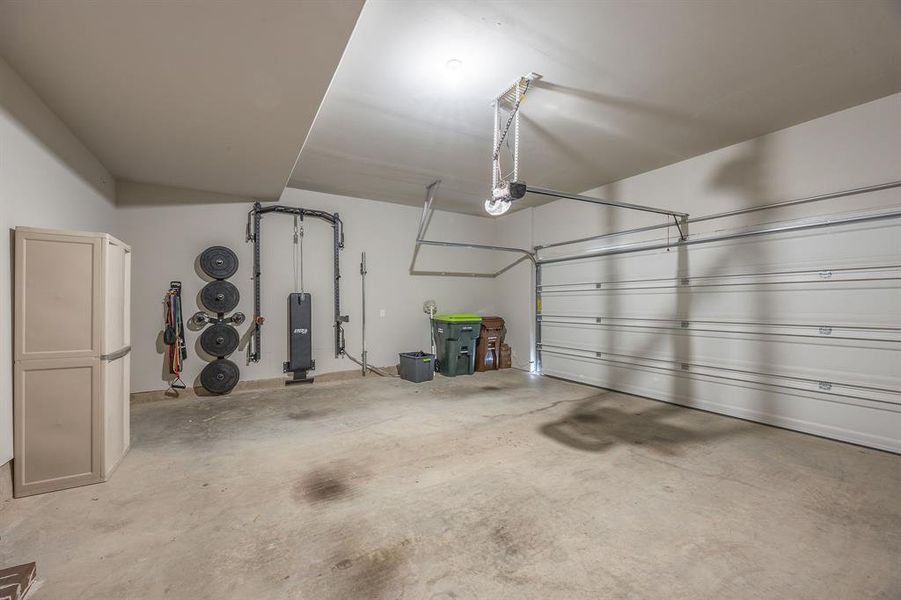 2 car garage with door opener and retractable workout weight station that can convey to the new buyer - View