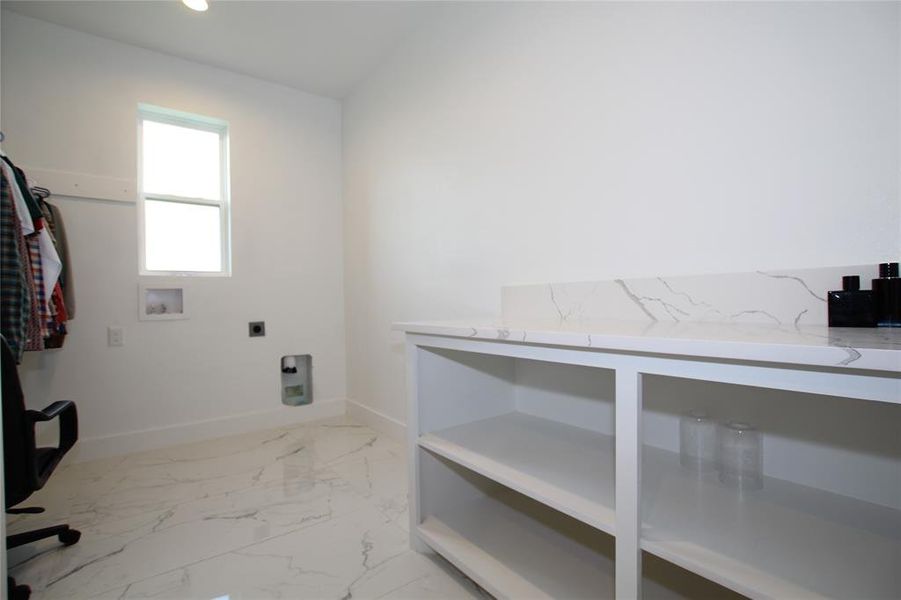 Laundry room with washer hookup, electric dryer hookup, and light marble finish floors Laundry room with washer hookup, electric dryer hookup, and light marble finish floors