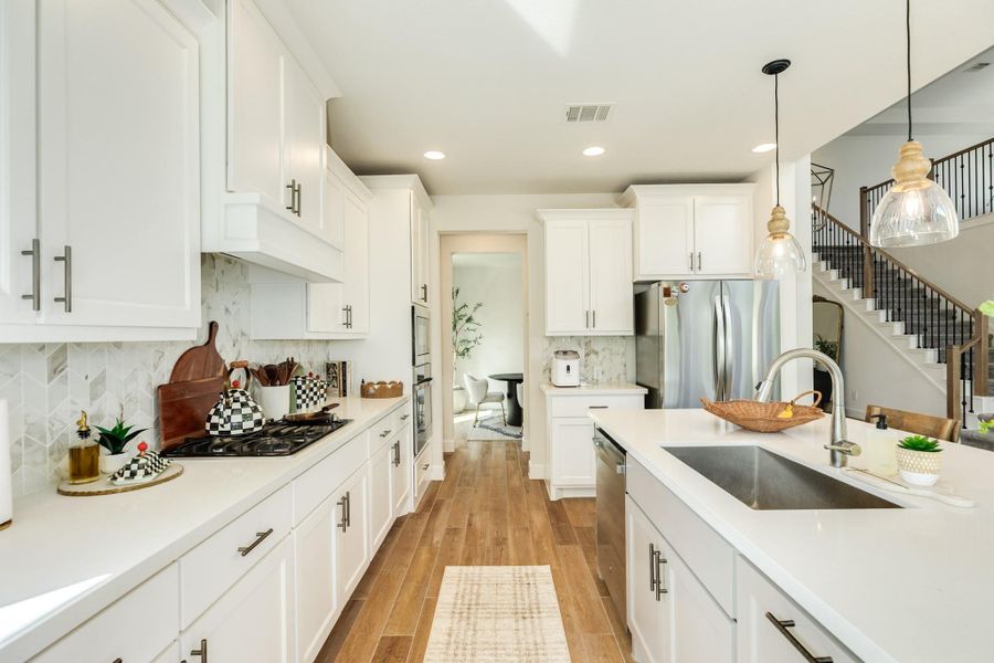 This gourmet kitchen features a convenient beverage bar positioned adjacent to the refrigerator. The walk-in pantry is strategically located in the doorway to the right, ensuring effortless access for both the kitchen and dining areas. This gourmet kitchen features a convenient beverage bar positioned adjacent to the refrigerator. The walk-in pantry is strategically located in the doorway to the right, ensuring effortless access for both the kitchen and dining areas.