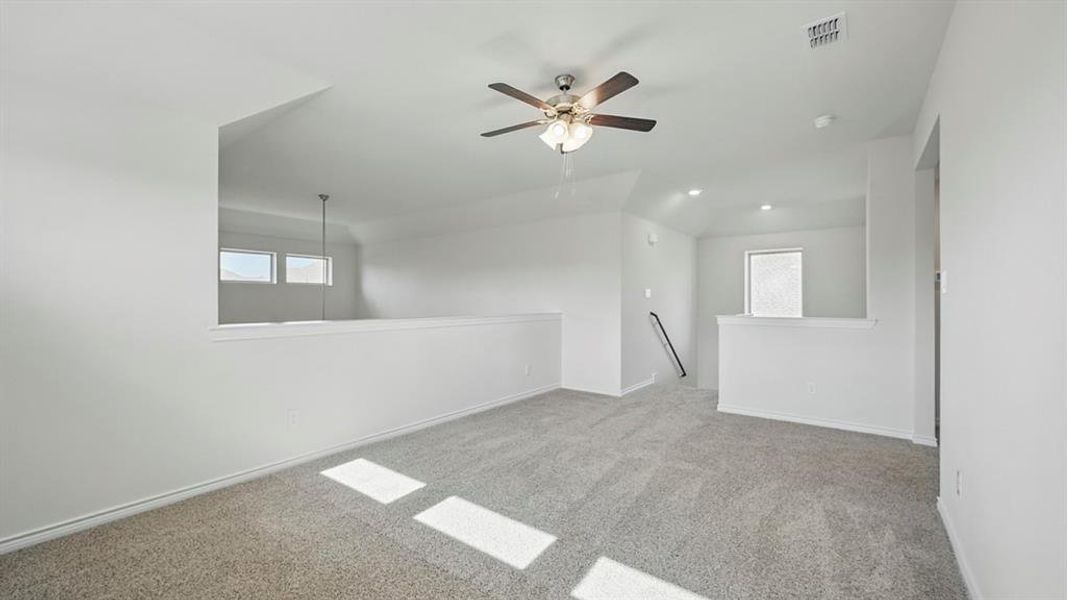 Spacious upper-level area featuring plush carpeting and a ceiling fan Spacious upper-level area featuring plush carpeting and a ceiling fan