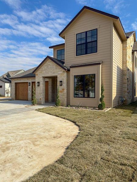 Contemporary two-story exterior featuring a stone and siding facade