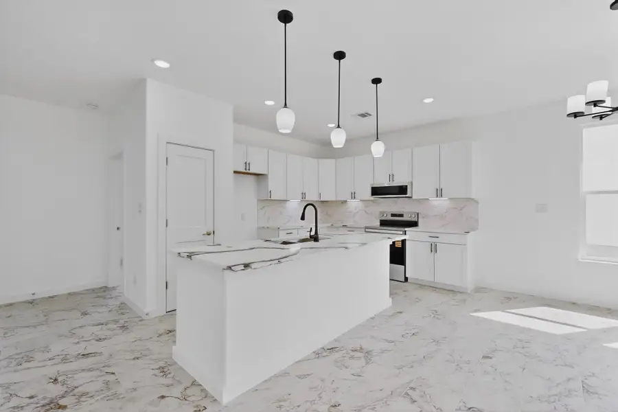 Kitchen with light, and stainless-steel electric range oven, white cabinetry, and pendant lighting