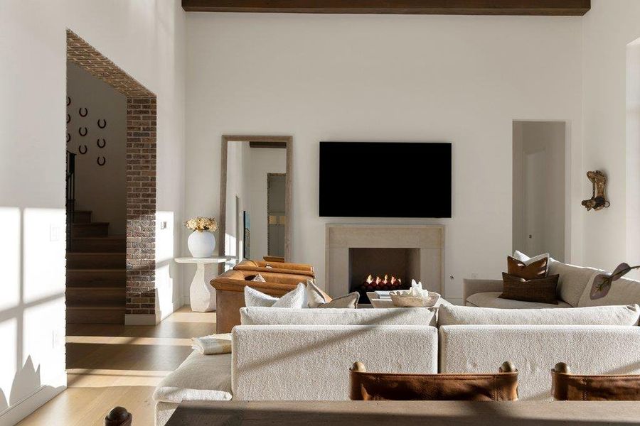 Living area featuring wood finished floors and a warm lit fireplace