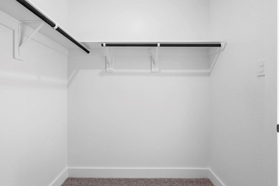 Just off the bathroom, the primary closet offers generous space and smart organization, with built-in shelving, hanging areas, and room for shoes and accessories.