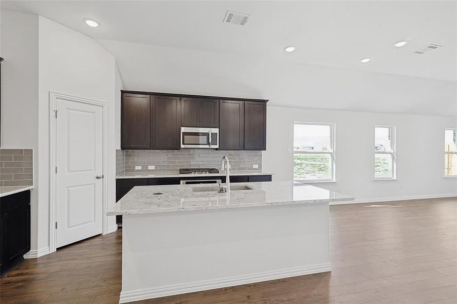 Kitchen featuring hardwood / wood-style flooring and an island with sink