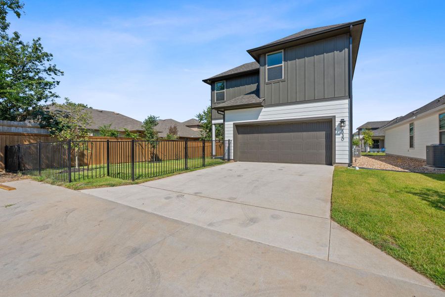 View of front of property with board and batten siding, a garage, driveway, and a shingled roof