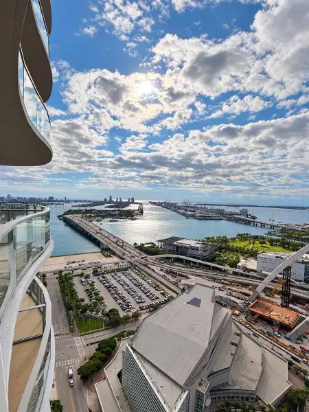 High-rise balcony featuring glass railings and a curvilinear architectural profile