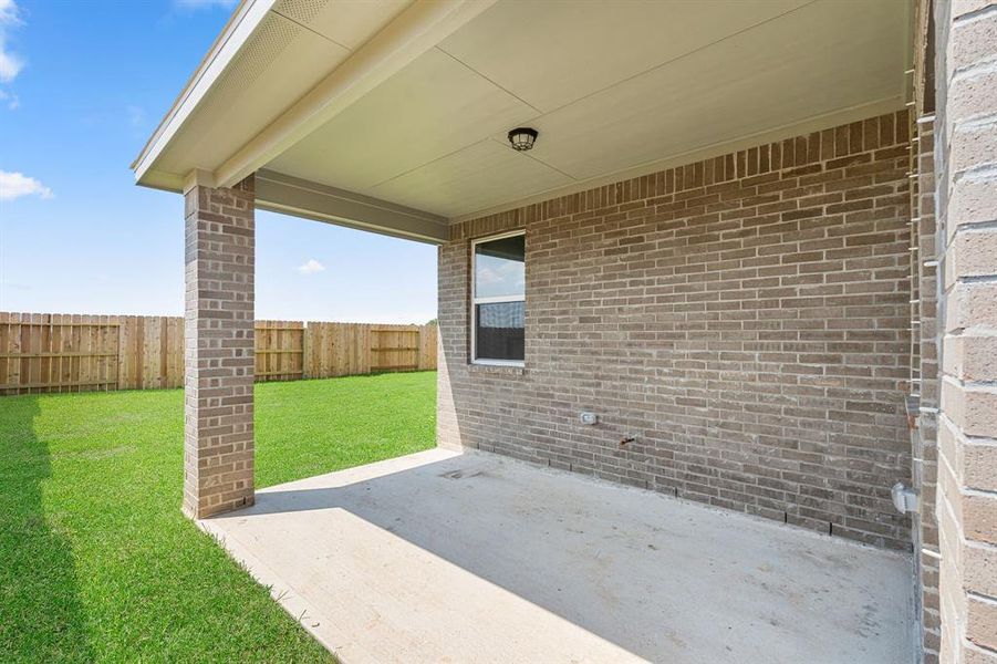 The covered patio is generously sized, providing ample space for various outdoor activities.