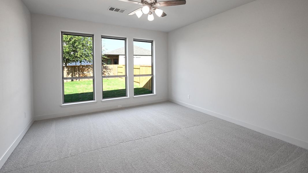 Carpeted spare room with a ceiling fan and baseboards Carpeted spare room with a ceiling fan and baseboards