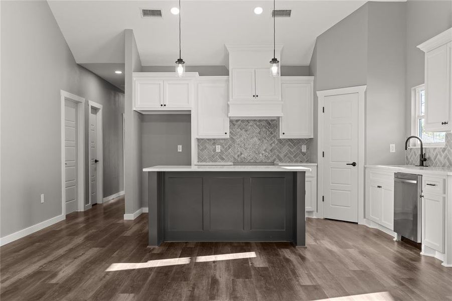 Kitchen with white cabinetry, backsplash, pendant lighting, a kitchen island, and recessed lighting
