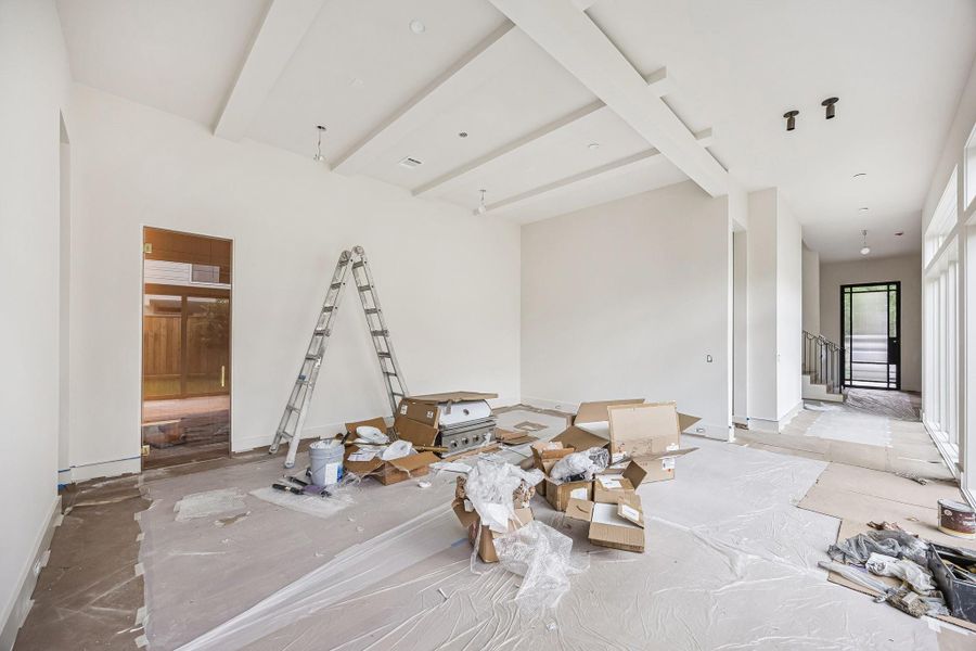 Expansive Dining Room across from a wall of windows that look out onto the courtyard. There is also a Wine Reserve behind the Dining Room. Incredible ceiling detail with horizontal beams. Construction as of June 1st, 2026.