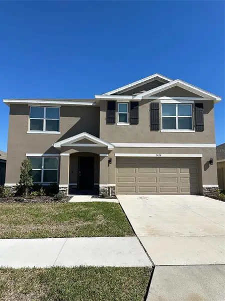 Front exterior of a new home in Berry Bay, Wimauma, FL, highlighting curb appeal (Image 7).