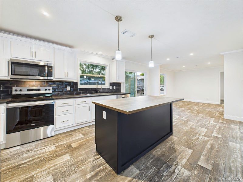 Large center island with pendant lighting and breakfast bar seating.