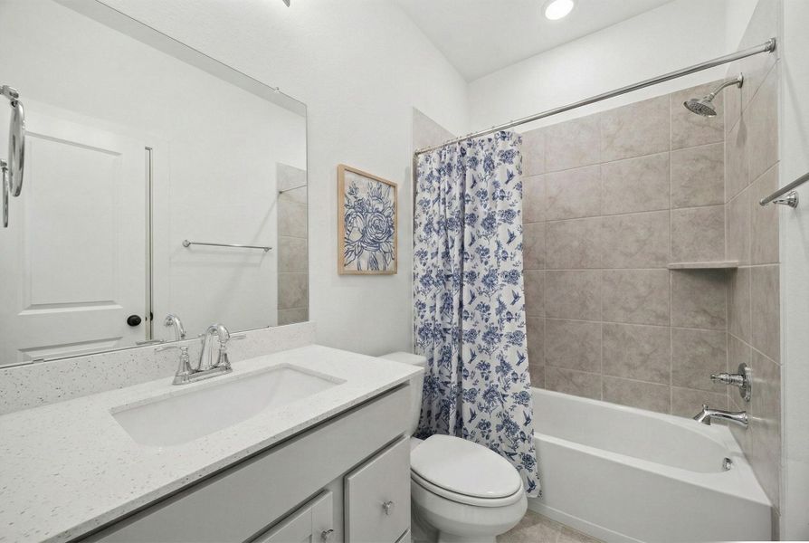 A SECONDARY BATHROOM INCLUDES A VANITY WITH STORAGE AND A TUB & SHOWER COMBO.