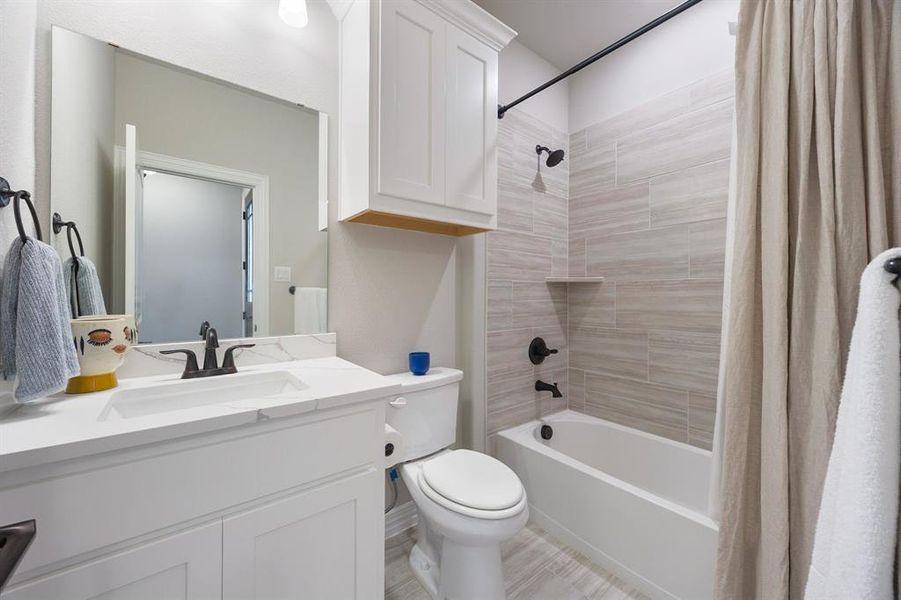 Bathroom with shower / bath combination with curtain and vanity