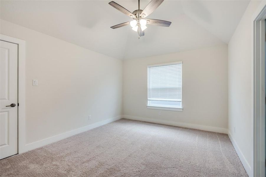 Unfurnished room with vaulted ceiling, carpet, a ceiling fan, and baseboards Unfurnished room with vaulted ceiling, carpet, a ceiling fan, and baseboards