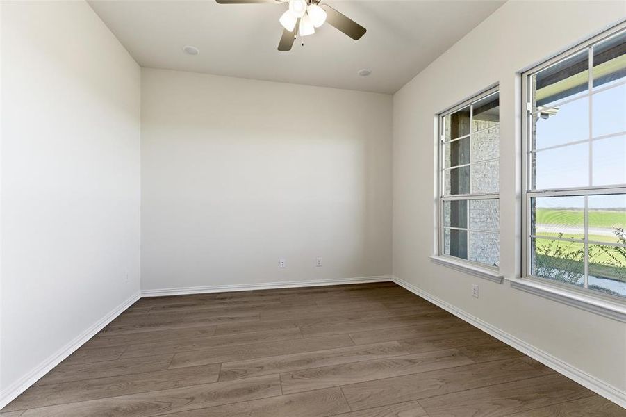 Unfurnished room with wood finished floors and a ceiling fan