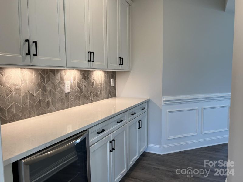 Butler's Pantry with upper and lower cabinets and wine refrigerator.