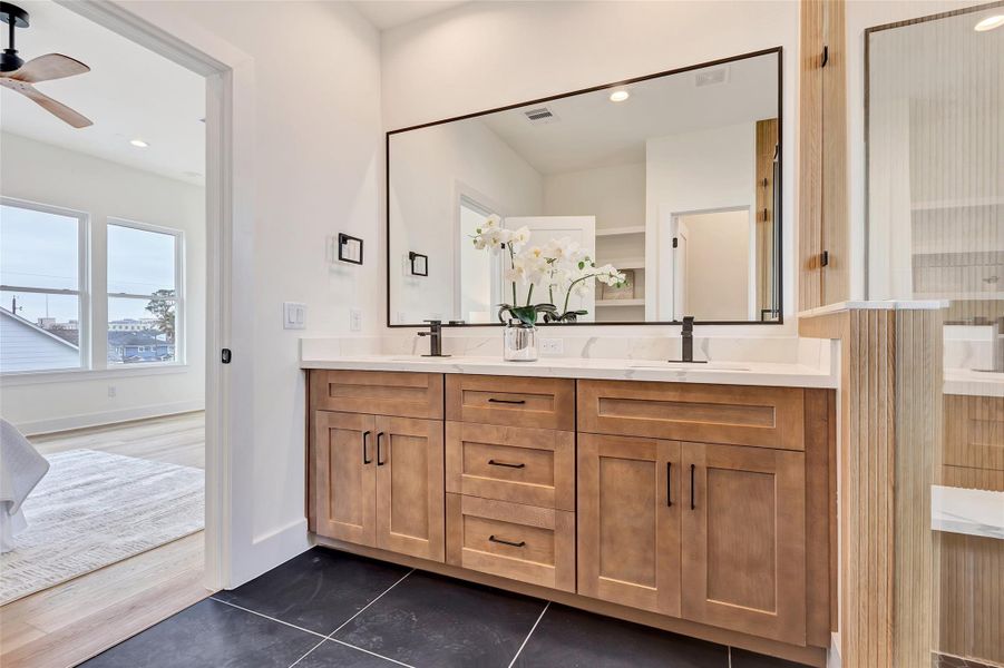 Detailed view of the stylish vanity in the bathroom, with a glimpse of the spacious main bedroom just through the bathroom door. Detailed view of the stylish vanity in the bathroom, with a glimpse of the spacious main bedroom just through the bathroom door.