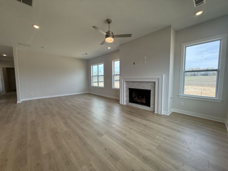 Unfurnished living room featuring recessed lighting, a ceiling fan, a brick fireplace, and light wood-style flooring