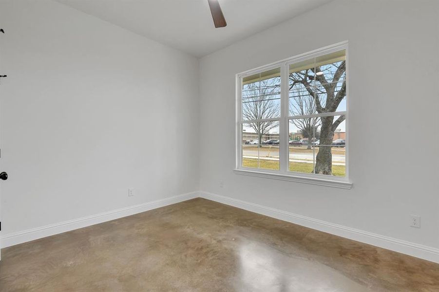 Spare room featuring concrete floors and ceiling fan