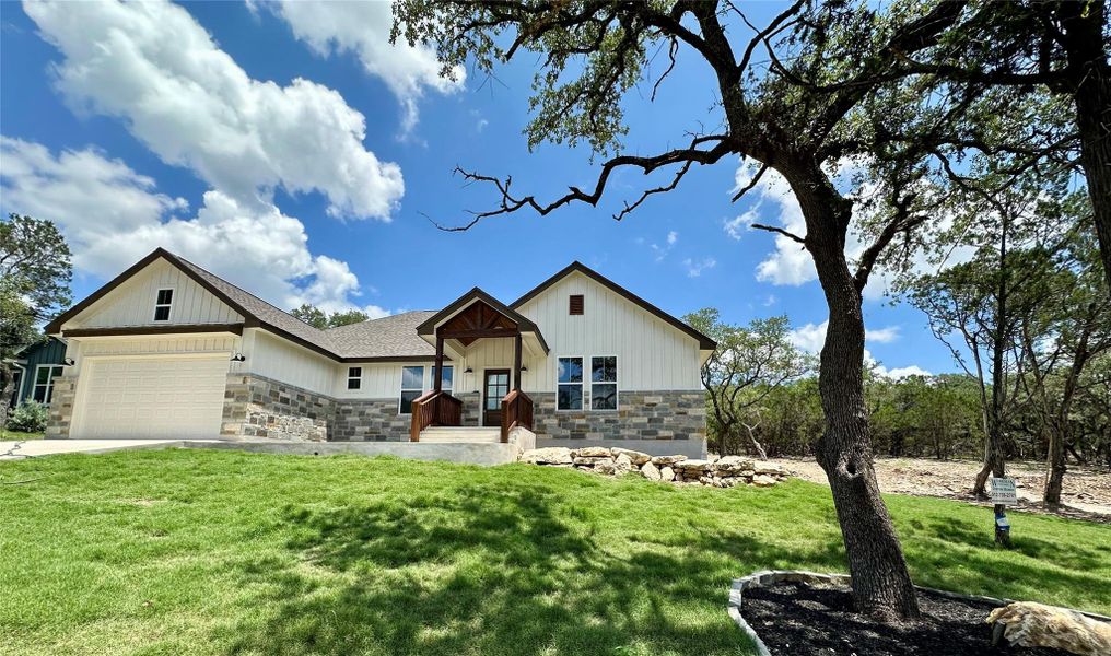 View of front facade with stone siding, a front lawn, and concrete driveway View of front facade with stone siding, a front lawn, and concrete driveway