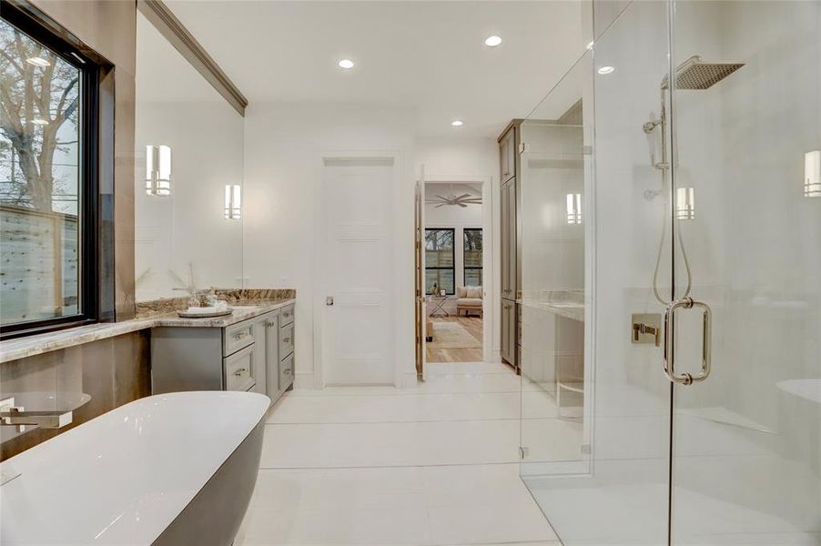 ANOTHER VIEW:  Dramatic tiled wall with oversized ledge accents the black freestanding tub.  Note the corner seat, along with both handheld and rain head on each end of the generous walk-in shower.