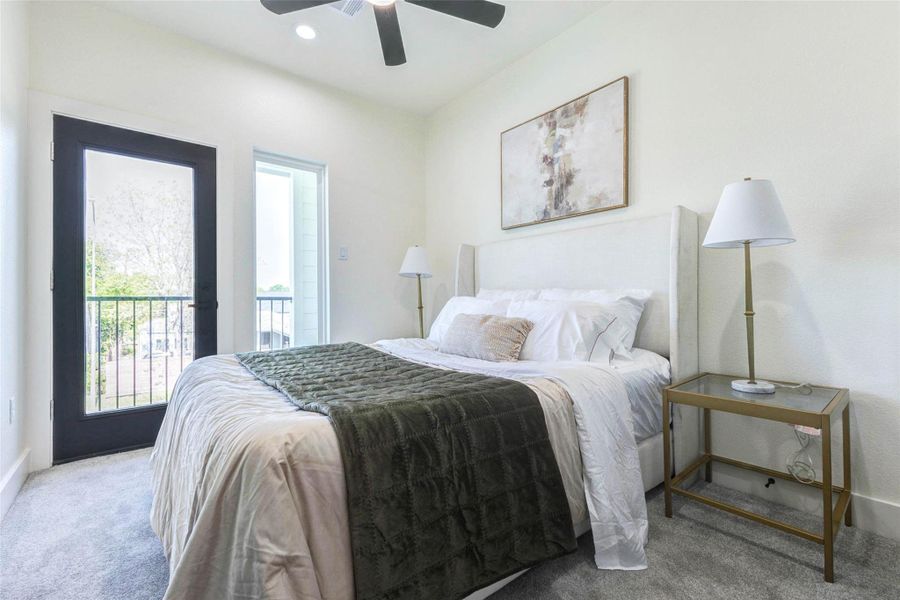 This secondary bedroom offers soft neutral carpeting and direct access to a private outdoor space through a full-lite glass door.