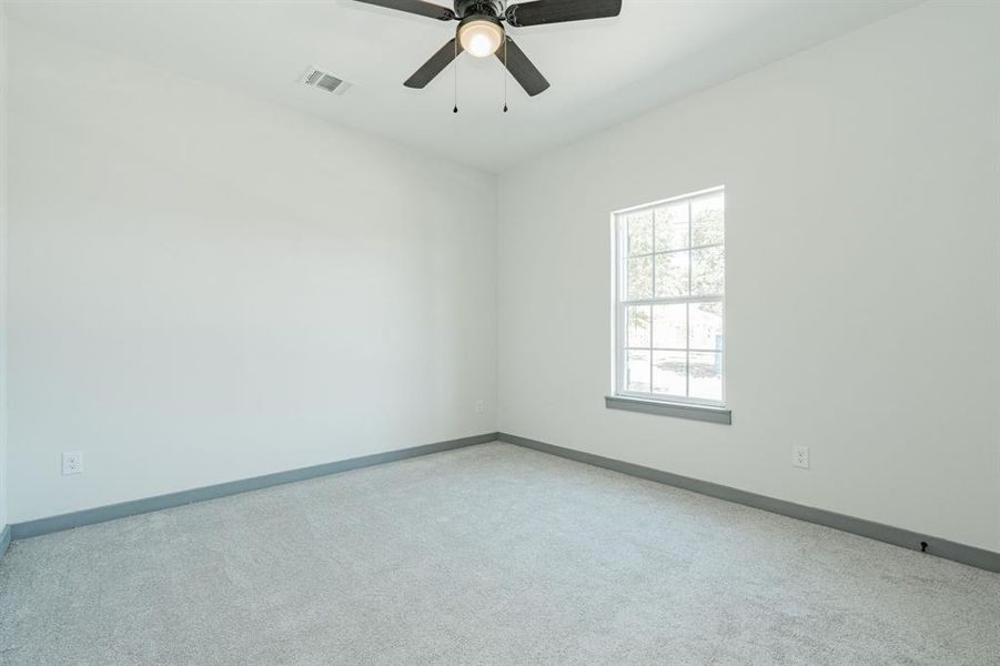 Carpeted spare room with ceiling fan