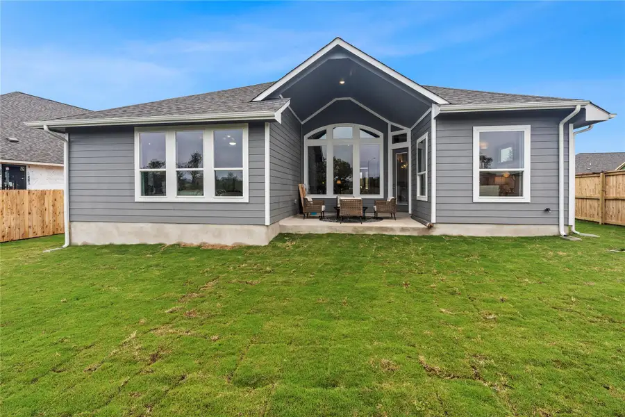 Rear view of house featuring a fenced backyard and a patio