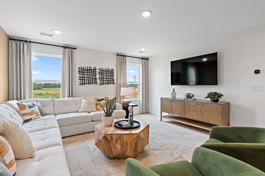 A living room with a tv and couches. A living room with a tv and couches.