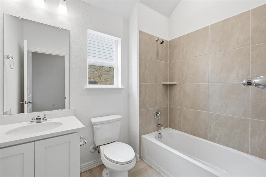 Bathroom featuring a white vanity with integrated sink, chrome faucet, and a large wall-mounted mirror