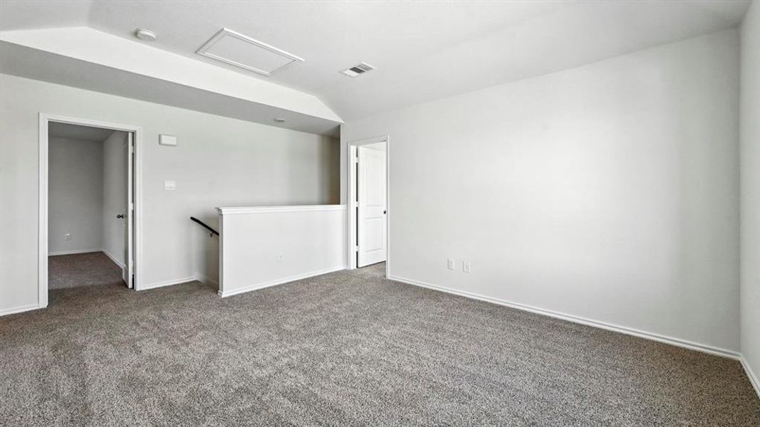 Spacious upper-level room featuring neutral gray carpeting and white painted walls