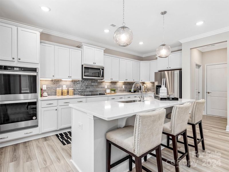 Representative Photo-Actual home for sale has a gas cooktop and hood vent, and a wall oven/microwave in leu of double oven pictured.