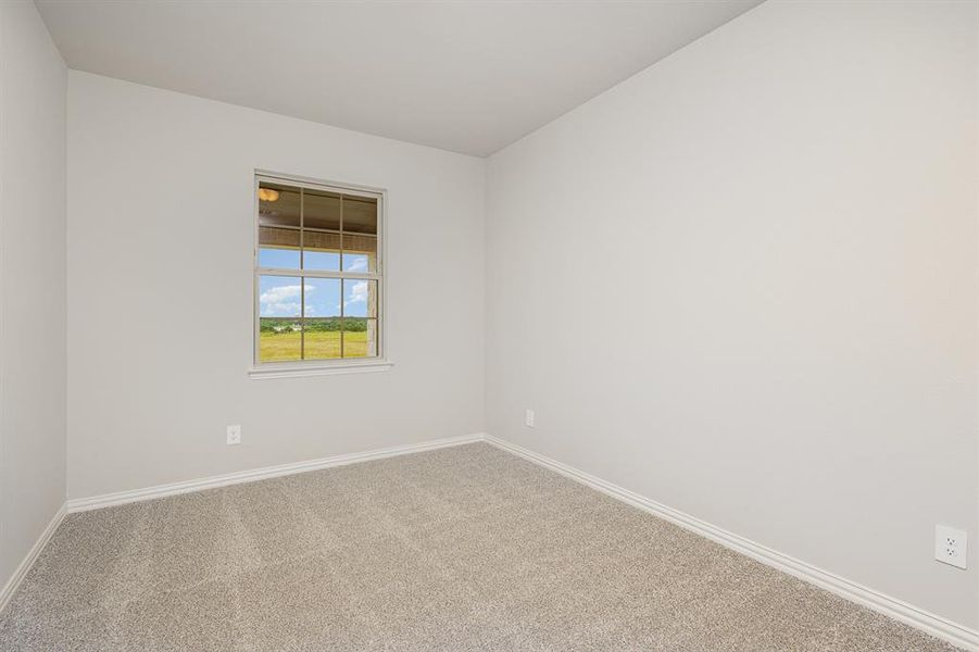 Carpeted spare room featuring baseboards