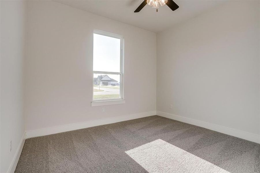 Empty room with ceiling fan and carpet flooring