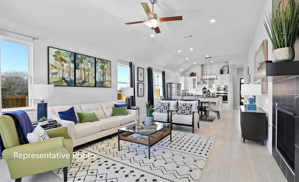 Living room featuring vaulted ceiling, ceiling fan, and recessed lighting