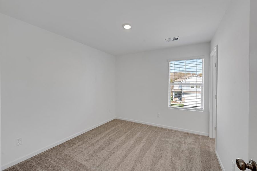 A room with a window and a rug.