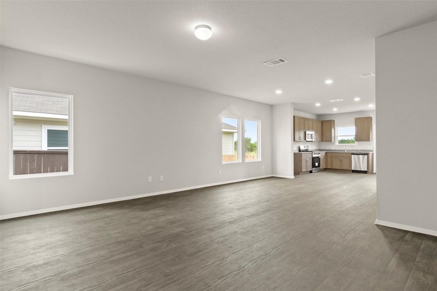 Unfurnished living room featuring recessed lighting and dark wood-style flooring