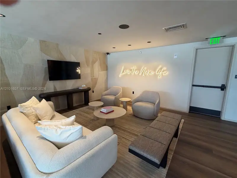 Recessed lighting, wood-finish flooring, and an accent wall featuring textured wallcovering