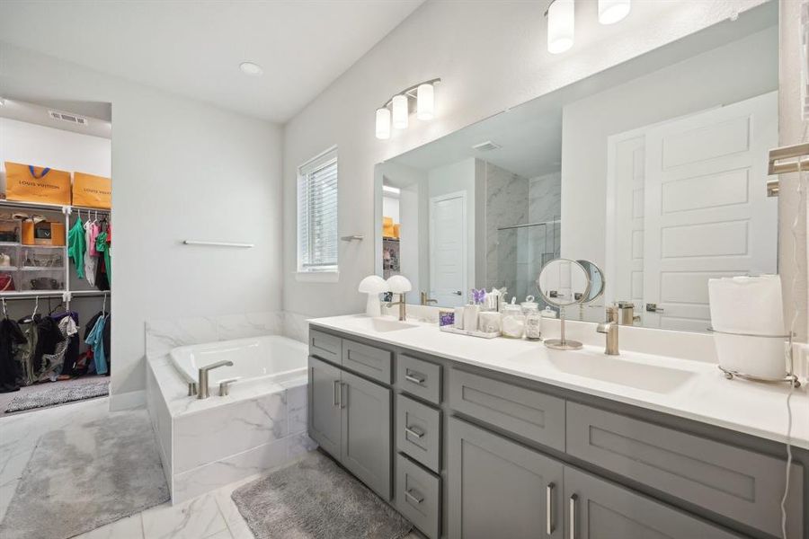 Bathroom featuring vanity and independent shower and bath