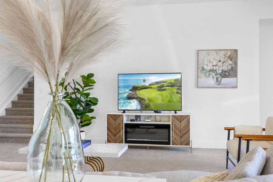 Living area featuring carpet and stairs