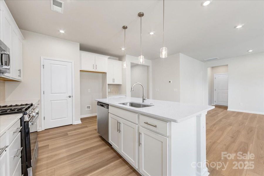 Large Central Island with Pendant Lighting Adding Warmth the the Space.