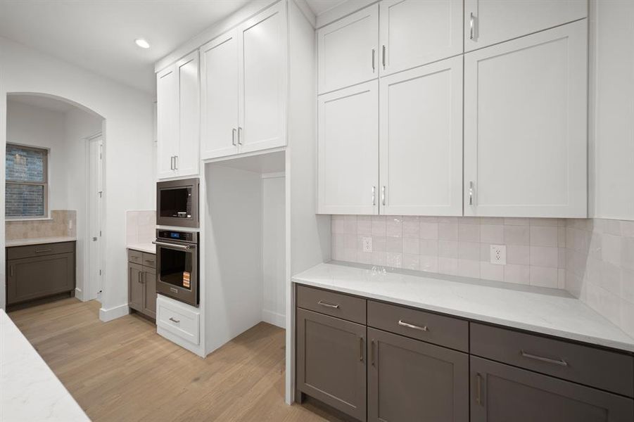 Kitchen with white cabinets, tasteful backsplash, appliances with stainless steel finishes, and recessed lighting