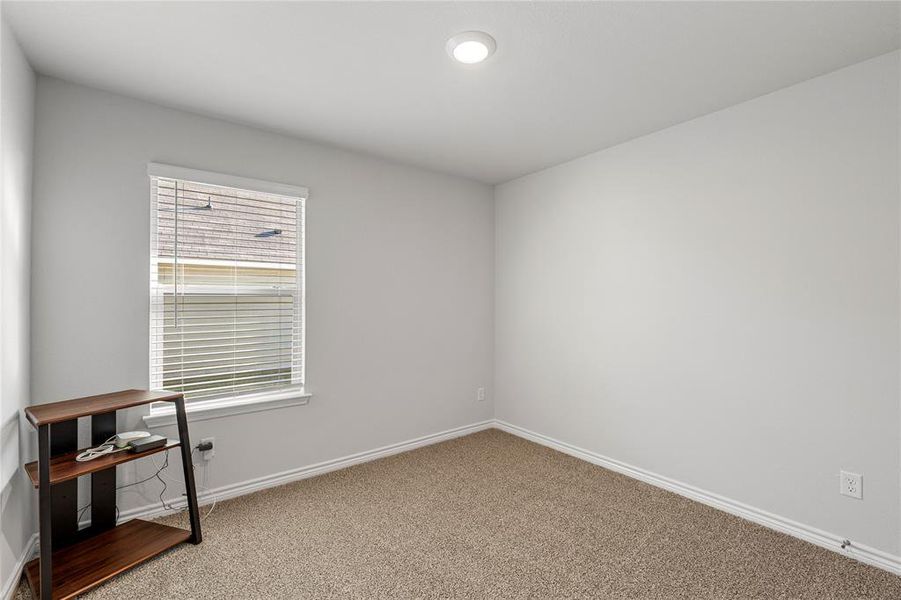 Carpeted empty room featuring baseboards